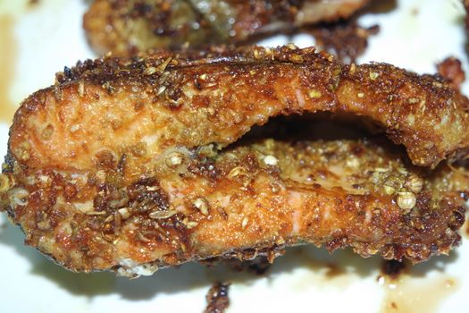 Spicy and crunchy barbecue of fried fish fillet on a white background. Homemade grilled trout fish steaks for health nourishments.