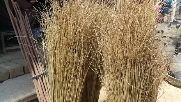 Bunch of brown colored straw broom. Old style broom used for housekeeping in rural area in Asian countries.
