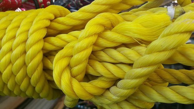Closeup of bright color braided plastic ropes. Hanks or coil of bright colored plastic rope interwoven which are used for climbing and tightening materials.