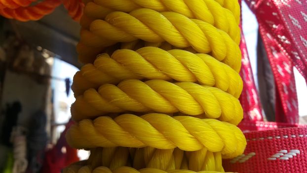Closeup of bright color braided plastic ropes. Hanks or coil of bright colored plastic rope interwoven which are used for climbing and tightening materials.
