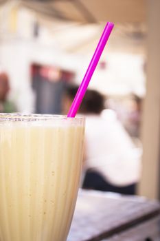 Glass bowl with fruit smoothie and drinking straw