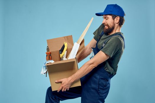 Worker man in uniform box tools construction blue background. High quality photo