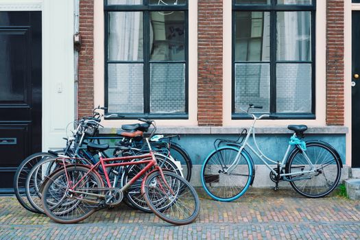 Bicecles which are a very popular transport in Netherlands parked in street near old houses. Utrecht, Netherlands