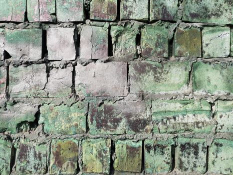 Old brick wall with remains of paint. Background texture closeup.