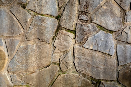 Background wall of stones. The surface of the stones is brown. Background texture