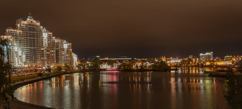 Urban landscape. The lights of the night city are reflected on the surface of the water. Stock photo