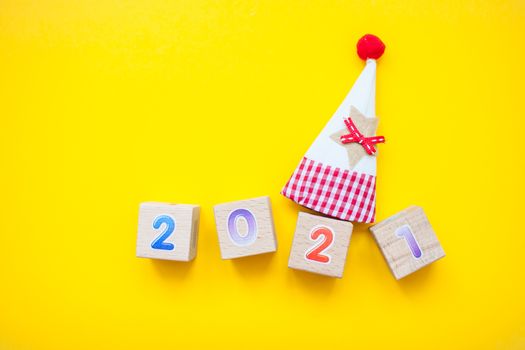 Happy New year 2021 celebration. The inscription 2021 from children's educational wooden cubes on a bright yellow background