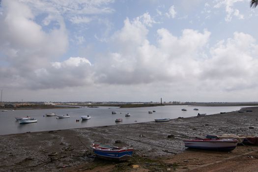 Fishing bay with boats at sea and in the mud and crabs walking in the sand