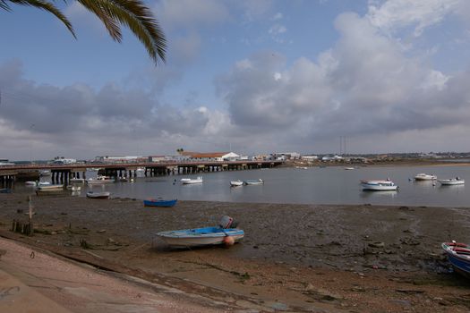 Fishing bay with boats at sea and in the mud and crabs walking in the sand