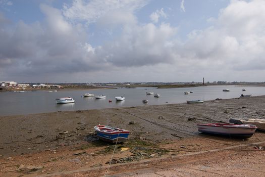 Fishing bay with boats at sea and in the mud and crabs walking in the sand