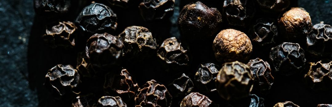 Black pepper closeup on luxury stone background as flat lay, dry food spices and recipe ingredients