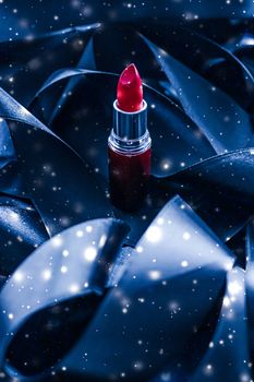 Red lipstick on blue silk and shiny glitter background, luxury make-up and beauty cosmetics