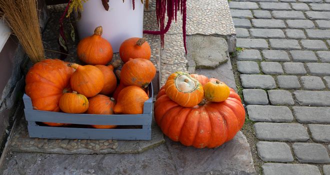 Orange pumpkins of various sizes lie on the porch of the house.The Concept Of Halloween.