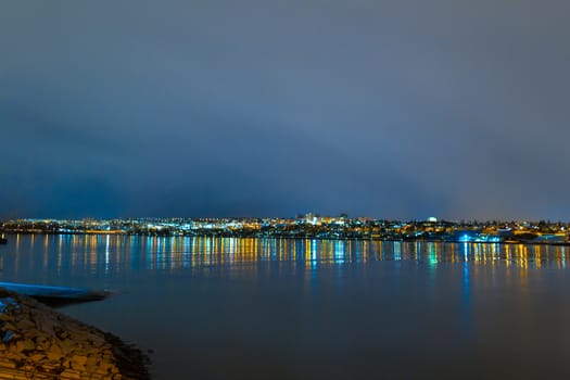 Night photo of Reykjavik city beach. Waterfront lights.