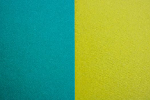 Blue-yellow background of matte suede, close-up. Velvety texture.