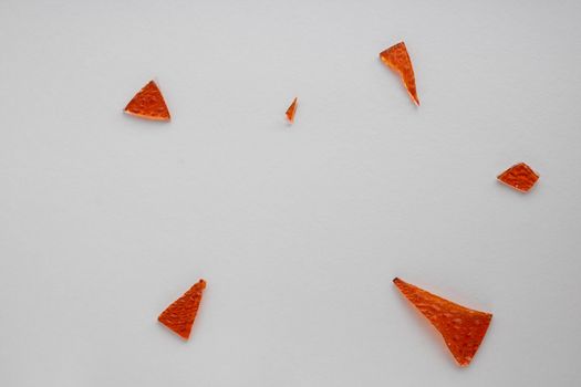 Broken orange glass background for your images isolated on a white background. A lot of shards fell apart.