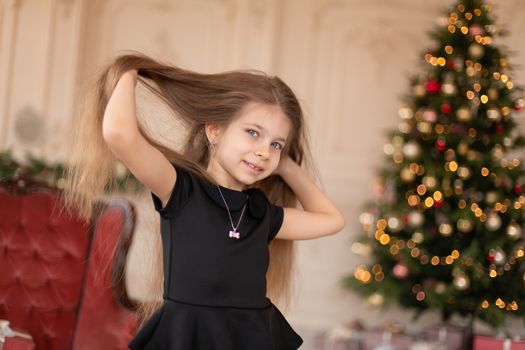 A little girl opens a Christmas present from Santa. Christmas tale. Happy childhood.