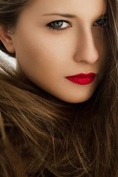Closeup beauty portrait of a woman with classy makeup look and perfect skin, brunette with long healthy brown hair, female model posing for luxury cosmetics or luxe skincare brands