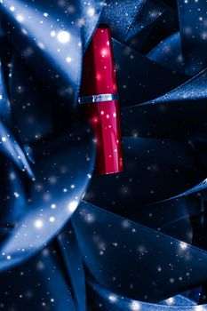 Red lipstick on blue silk and shiny glitter background, luxury make-up and beauty cosmetics