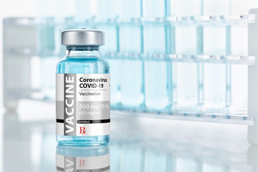 Coronavirus COVID-19 Vaccine Vial Near Test Tubes On Reflective Surface.