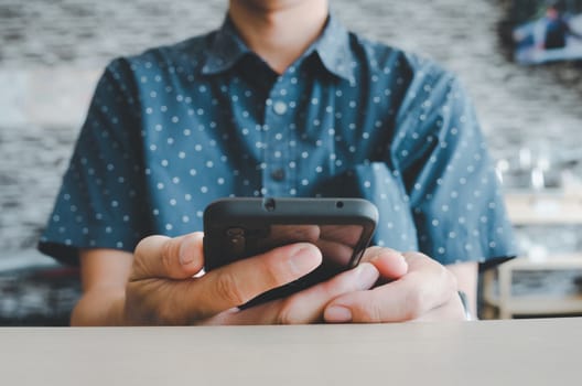 man using mobile smart phone in coffee shop.