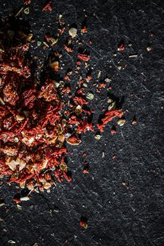 Dried tomato and chili pepper closeup on luxury stone background as flat lay, dry food spices and recipe ingredients