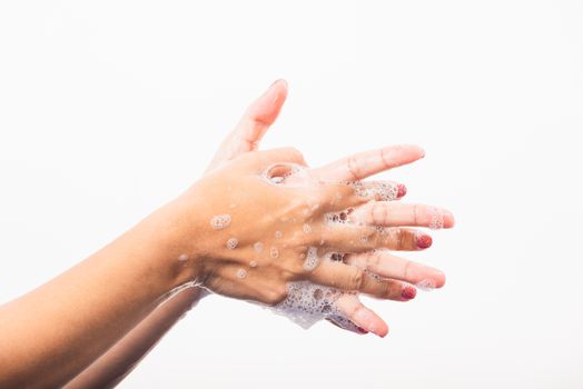 Closeup young Asian woman washing hands by soap for cleanliness and prevent germs coronavirus, studio shot isolated on white background, Healthcare medical COVID-19 virus concept