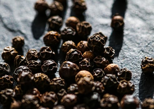 Black pepper closeup on luxury stone background as flat lay, dry food spices and recipe ingredients