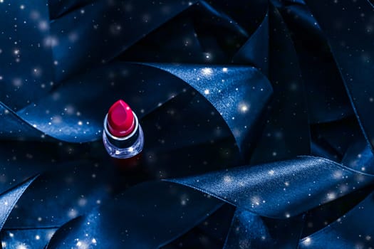 Red lipstick on blue silk and shiny glitter background, luxury make-up and beauty cosmetics