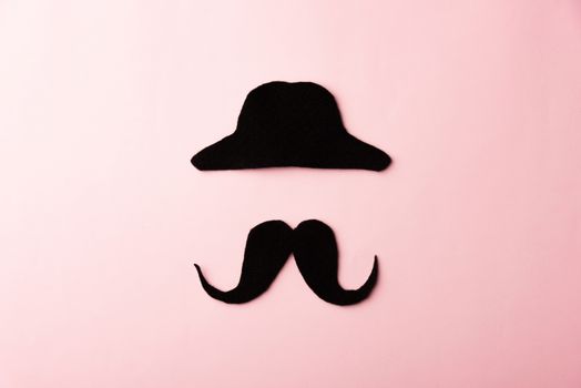 Black mustache and cap, studio shot isolated on pink background, Prostate cancer awareness month, Fathers day, minimal November moustache concept