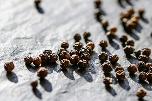 Black pepper closeup on luxury stone background as flat lay, dry food spices and recipe ingredients