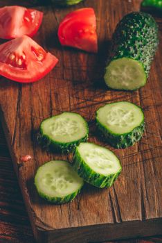 Sliced vegetables. Tomatoes, cucumbers and chili peppers over wooden background.