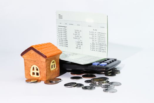 Model house with coin, calculator, book bank, concept 
Collecting money Buying a house, residence, business, finance