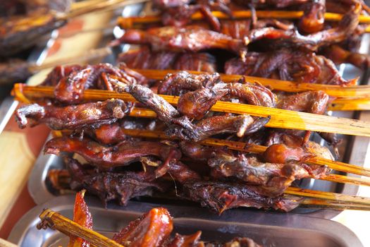 Laos, street food. Traditional food cooked at road sides in stalls on skewers for grilling, chicken, fish, birds High quality photo