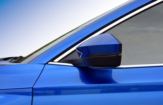 Car detail. Side mirror with turn signal of a luxury car.