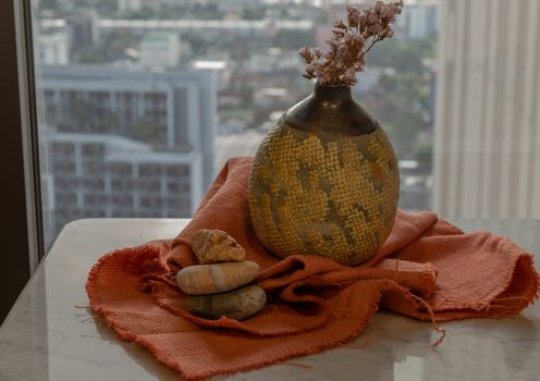 Dried flowers in beautiful ceramic yellow vase handmade on marble table of living room and city view. Home decor. Space for text. Selective focus.