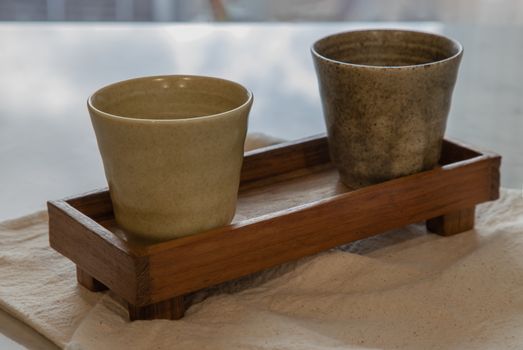 Two ceramics mugs handmade on marble table of living room. Home decor. Space for text. No focus, specifically.