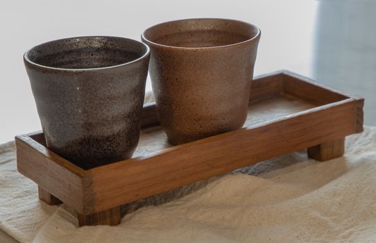 Two ceramics mugs handmade on marble table of living room. Home decor. Space for text. No focus, specifically.