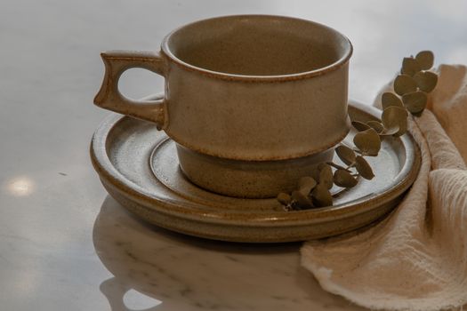 Ceramic mug handmade with Dried flower on marble table of living room. Home decor. Space for text. Selective focus.