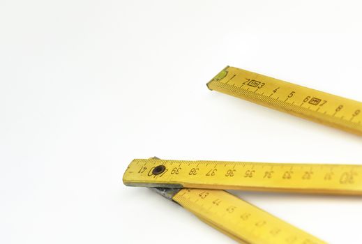 a yellow wooden folding ruler isolated on a white background. Measuring instrument. Construction and home renovation