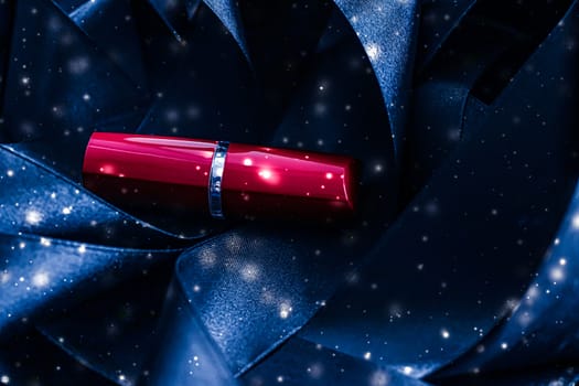 Red lipstick on blue silk and shiny glitter background, luxury make-up and beauty cosmetics