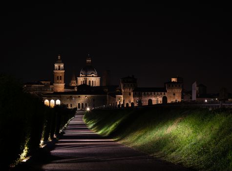 Night walk towards the city of Mantua, Italian urban landscape illuminated by night lights