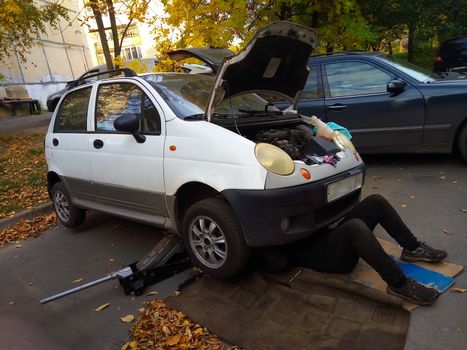 Repair of a small old car in the city yard.