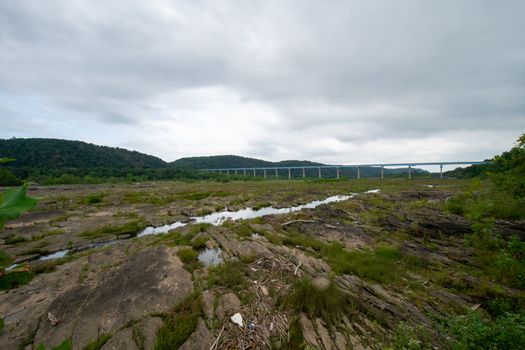 A Huge Sprawling Landscape Covered in Rock Formations and Plants With the Norman Wood Bridge in the Background