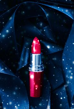 Red lipstick on blue silk and shiny glitter background, luxury make-up and beauty cosmetics