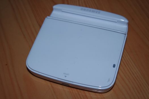 White colored battery charging box for electronic devices like mobile phone. Potable charging box is placed on a wooden floor.
