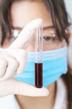 Technician scientist analyzing holding blood sample in test tube in laboratory for testing it on COVID, COVID-19, coronavirus virus analysis
