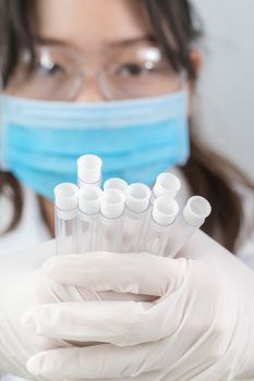 Technician scientist analyzing holding test tube in laboratory for testing it on COVID, COVID-19, coronavirus virus analysis