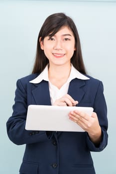 Asian teenage girl in suit using computer digital tablet isolate on blue background