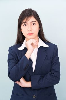 Teenage young girl wearing suit with hand on chin isolated on blue background